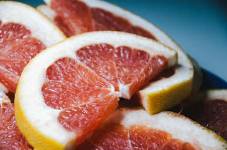 Closeup of slices of grapefruit. Fruit on the plate with white backgroundの写真素材
