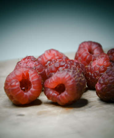 Raspberry on the wooden plate on white backgroundの写真素材