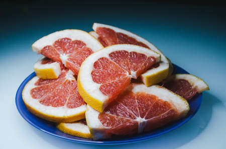 Closeup of slices of grapefruit. Fruit on the plate with white backgroundの写真素材