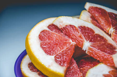 Closeup of slices of grapefruit. Fruit on the plate with white backgroundの写真素材