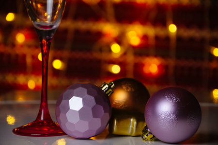 Christmas toys on the white table with a glass. Christmas background with lightsの写真素材