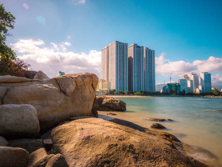 Rocks on the bayside with big city background. Tourist place with nice view. Summer vacation near oceanの写真素材