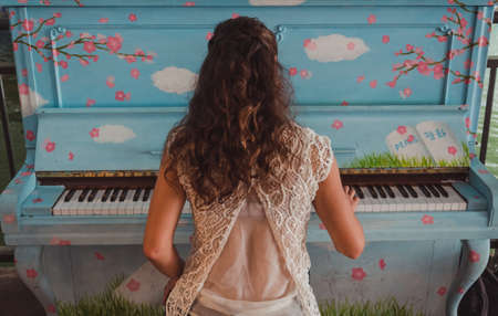 The girl plays the old piano, painted in different drawingsの写真素材