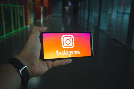 MIAMI, USA - 07.07.2019: A man holds a smartphone in his hand with the Instagram logo on the screenのeditorial素材
