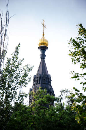 NIKOLAEV, UKRAINE - 04/07/2019: The top of the Orthodox church is visible behind the green treesのeditorial素材