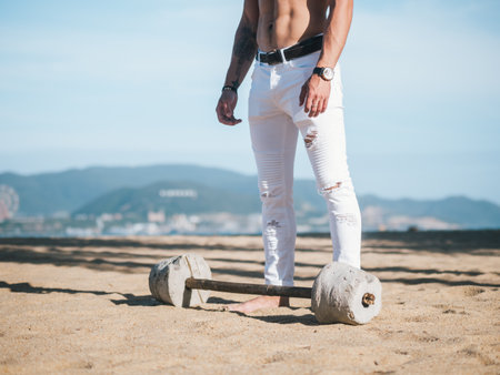 Close up of man with barbell on beachの写真素材