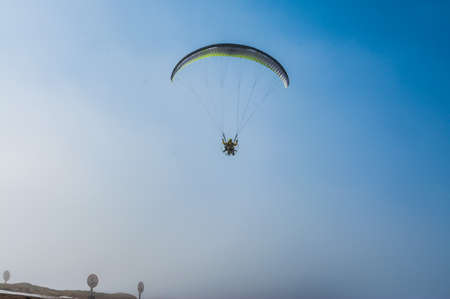 Parachutist flies against the blue sky. Motorized parachuteの写真素材