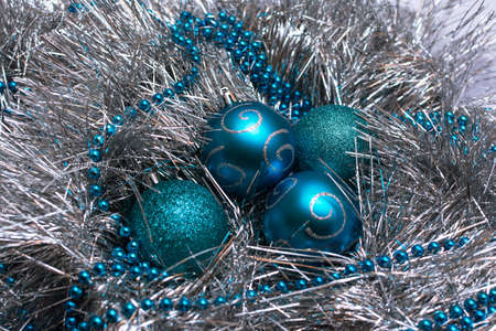 Christmas blue toys lie on a festive silver tinsel, top viewの写真素材