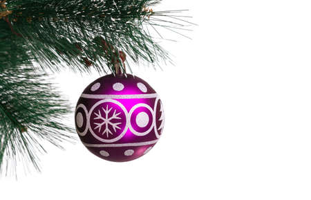 Christmas festive purple balloon with the image of a spruce and snowflakes for decoration hanging on artificial branches of a fir-tree on a white background, isolated, soft focusの写真素材