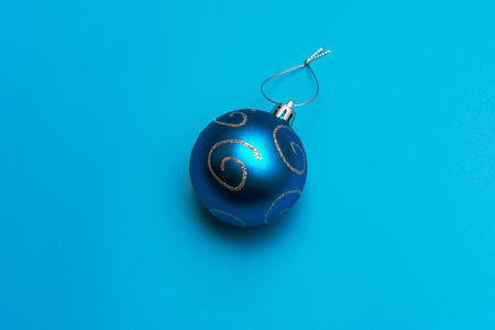 Christmas blue toy with silver spirals for decoration on a turquoise background