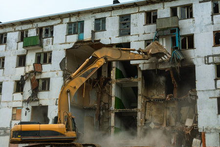 Demolition of a five-story apartment building recognized as emergency housing, excavator bucket...