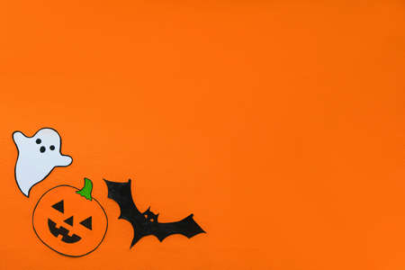 Carved scary figurines of ghost, pumpkin and bat on a yellow background, the concept of the holiday Halloween, space for textの写真素材
