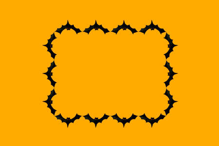 Paper cut black bats laid out in the form of a frame on an orange background, space for text, halloween conceptの写真素材