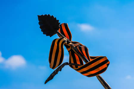 Forged iron leaf wrapped St. George ribbon on a background of blue sky, the celebration of the victory in the Second world warの写真素材