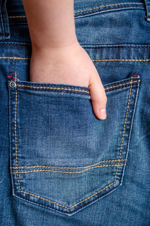 Hand in the back pocket of blue denim jeans, close-up of casual fashionの写真素材