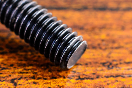 This macro shot highlights the details of the bolt's threads and the contrasting backgroundの写真素材