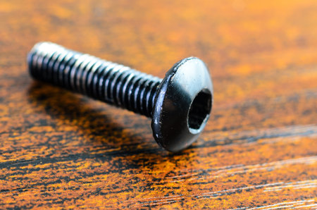 This macro shot highlights the details of the bolt, showcasing its threads and head against a textured backgroundの写真素材