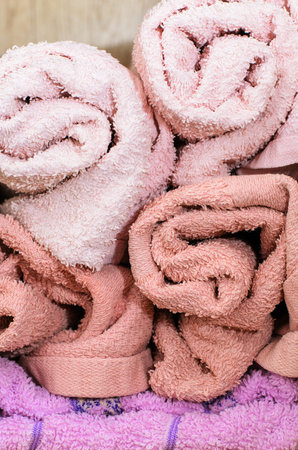 Soft, fluffy towels are neatly rolled, creating a visually appealing and inviting display for bathroom decorの写真素材