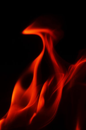 The vibrant red flames dance and swirl, creating a mesmerizing visual effect against the darkness
