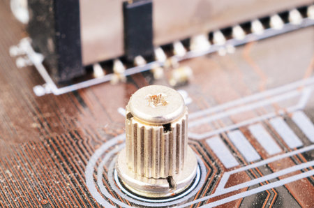 Macro close up of a mounting screw on a motherboard. Highlights computer hardware detail, assembly,...