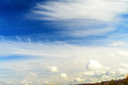 The clear blue sky and puffy clouds create a sense of peace and tranquility, perfect for any projectの写真素材