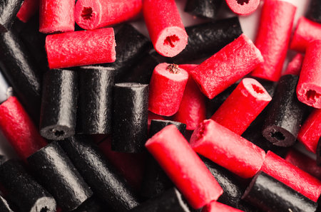 Close-up of red and black licorice candy pieces scattered randomlyの写真素材