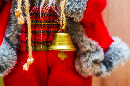Close-up of a festive Christmas bell ornament on a red and plaid backgroundの写真素材