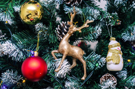 Christmas tree decorated with ornaments, including a reindeer and snowmanの写真素材