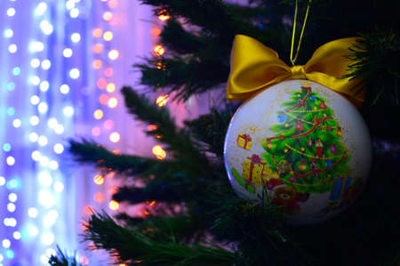 Beautiful, festive, Christmas, New Year's ball on a green spruce. flickering garlands in the backgroundの写真素材