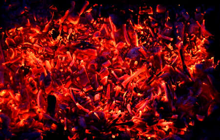 abstraction yellow-red coals smolder against the background of the night, the remains of firewoodの写真素材