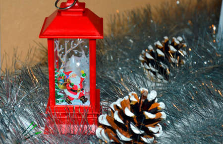 red christmas decorative lantern. near pine cones and silver tinselの写真素材