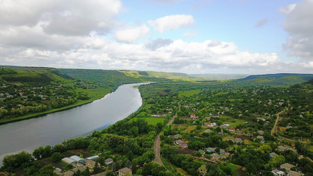 beautiful top view of the river, away the blue sky. on the river bank there is a village