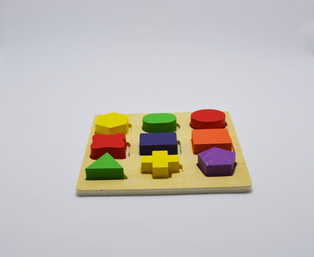 children's wooden figures of different shapes and colors on a white background. jigsaw toys for...
