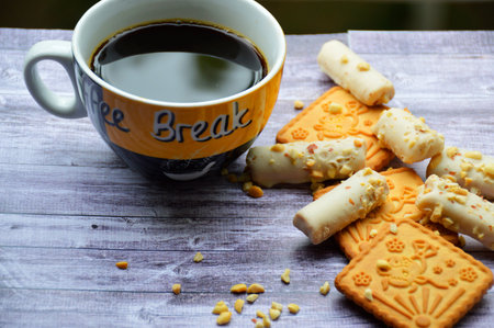 cup of black coffee and cookies on a wooden board background. invigorating morning coffee