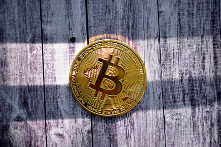 gold coin bitcoin lies on a background of wooden boards