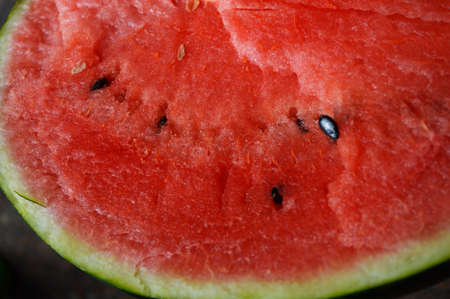 a cut watermelon inside has red juicy pulp and black bonesの写真素材