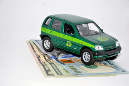 toy SUV green stands on dollar bills on a white backgroundの写真素材