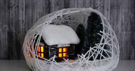 winter composition with a decorative house and handmade Christmas trees