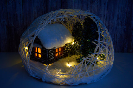 Christmas decorative composition with a house in the snow, artificial spruces are standing nearby...