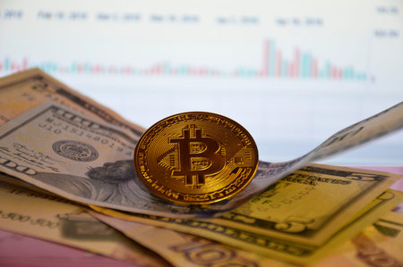 gold coin bitcoin on dollar bills, blurred stock chart in the background