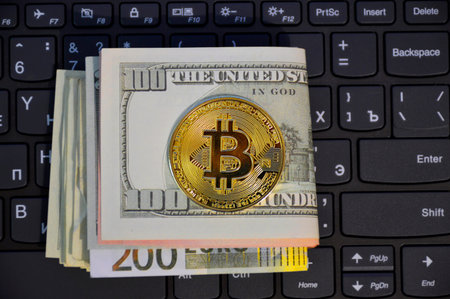 gold coin bitcoin and a stack of dollars and euros lie on a computer keyboard