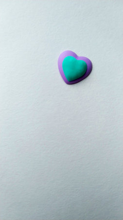two hearts of turquoise and violet colors of a light textured backgroundの写真素材