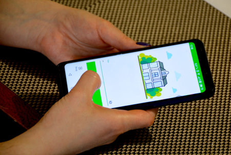 two female hands hold a switched on smartphone with an open application and press something