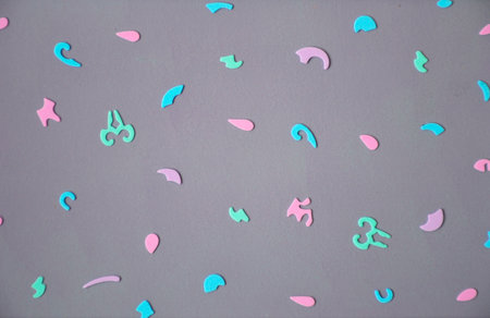 dark gray background with small colorful figures of different shapes and sizes