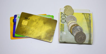 credit bank cards and paper euros on a white background, on top of the euro bills lie Russian coins...