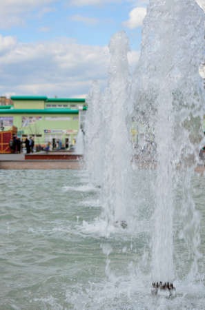 jets of a fountain in a city park throw water up to a small heightの写真素材