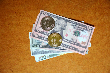 gold and silver bitcoin coins lie on expanded dollar bills, the concept of switching to non-cash and...