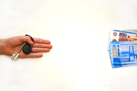 Men's hands. Money in exchange for the key.