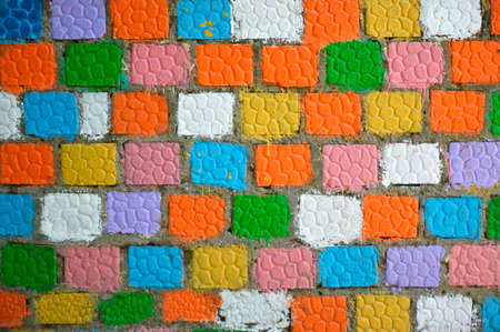 a bright wall of brick squares painted with multi-colored paints. wall decoration in preschool and school educational institutions and city parksの写真素材