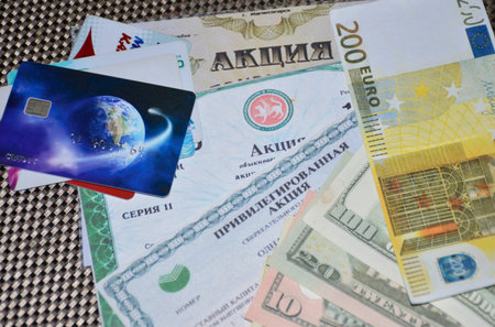 stocks, bank cards and dollar bills are laid out on the table